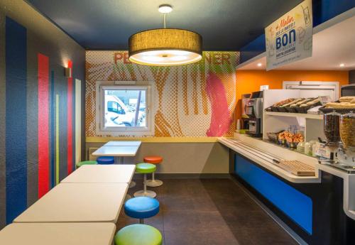 un fast food con pareti colorate e bancone di B&B HOTEL Cergy Pierrelaye a Pierrelaye