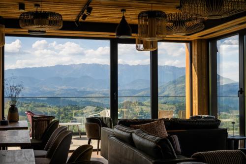 uma sala de estar com sofás e vista para as montanhas em The Pines Bucegi Lodge em Bran