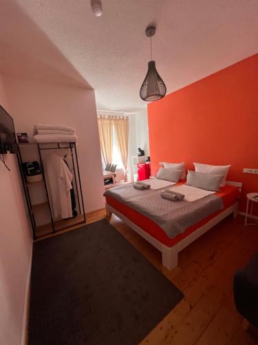 1 dormitorio con 1 cama con pared de color naranja en O&W Ferienhaus mit Pool nähe Nürburgring, Adenau, en Adenau