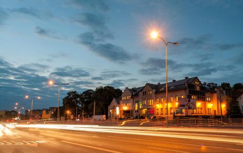 a street with buildings and a street light at night at Hotel POD HERBEM -POKOJE OZONOWANE in Białystok