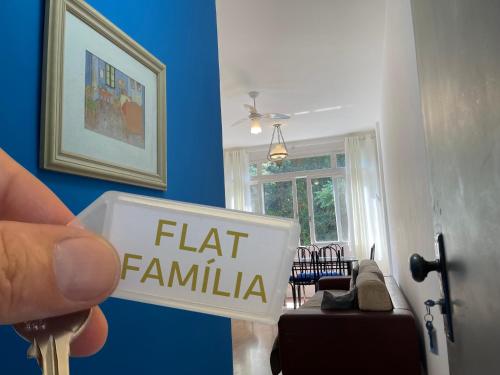 una persona con un cartello che legge "flat famille" di FLAT FAMÍLIA a Petrópolis