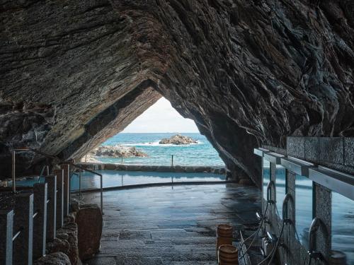 un túnel que conduce al océano a través de un muro de roca en Hotel Urashima, en Katsuura