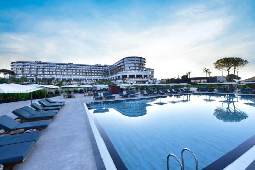 uma grande piscina com espreguiçadeiras e um hotel em Ethno Belek em Belek