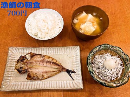 KoshigoeTrawl Guesthouse トロールゲストハウス Breakfast Options的一张桌子,上面放着一盘食物和一碗米