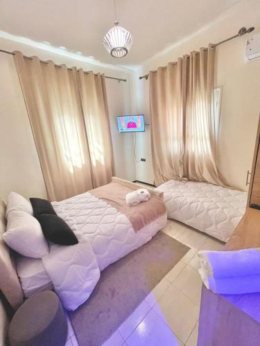 um quarto com uma cama grande e uma televisão em hotel darna with air conditioning em Er Rachidia