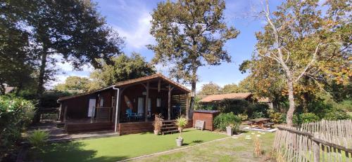 une petite maison avec une pelouse verte en face de celle-ci dans l'établissement Chalet prestige au coeur du Bassin d'Arcachon, à La Teste-de-Buch