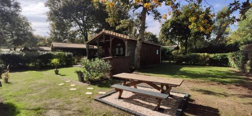 - une table de pique-nique en bois dans une cour avec une maison dans l'établissement Chalet prestige au coeur du Bassin d'Arcachon, à La Teste-de-Buch