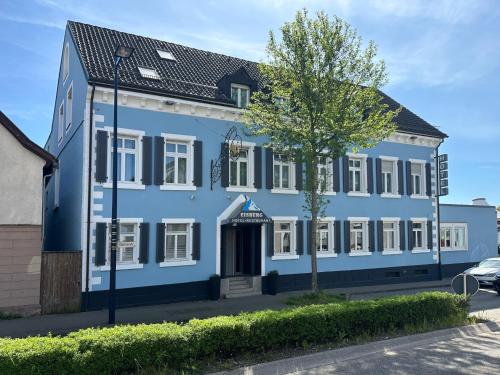 un edificio blu con un albero di fronte di Eisberg Hotel Schwanen a Lahr