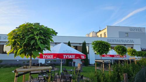 un hotel con tavoli e sedie di fronte a un edificio di Hotel Ossowski a Swarzędz