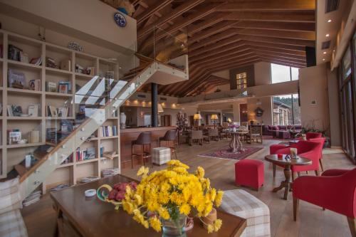 eine Lobby mit einer Treppe sowie Tischen und Stühlen in der Unterkunft Orizontes Tzoumerkon Hotel Resort in Pramanta