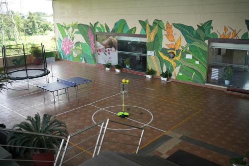 une chambre avec un terrain de basket en face d'une fresque murale dans l'établissement Flora Airport Hotel and Convention Centre Kochi, à Nedumbassery