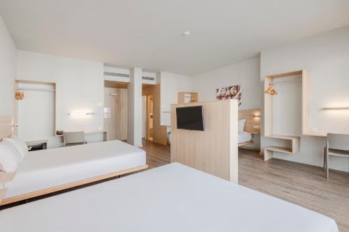 een hotelkamer met 2 bedden en een televisie bij Moov Hotel Porto Centro in Porto