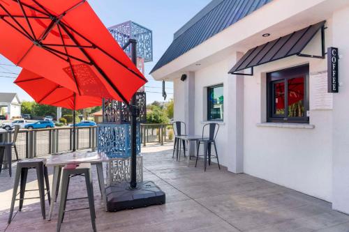 een tafel met een rode parasol op een patio bij Aiden by Best Western South Reno in Reno