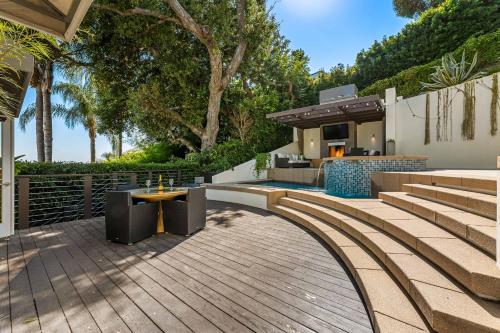 einen Hinterhof mit einer Holzterrasse und einem Haus in der Unterkunft West Hollywood Hills Jacuzzi and Beautiful View in Los Angeles