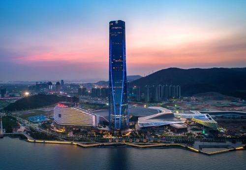 un gratte-ciel haut dans une ville la nuit dans l'établissement The St. Regis Zhuhai, à Zhuhai