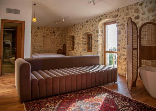 a large brown couch in a room with a bathroom at Zoe Hora in Dhërmi