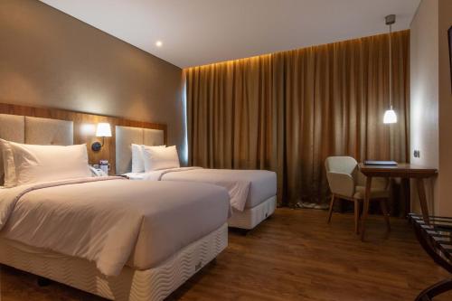 Tempat tidur dalam kamar di Avenzel Hotel & Convention Cibubur