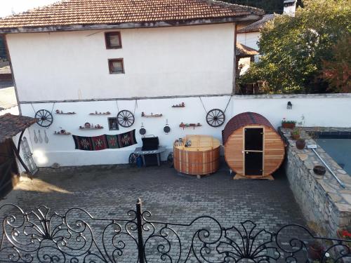 un edificio blanco con bañera de hidromasaje y barril en OldHouse, en Koprivshtitsa