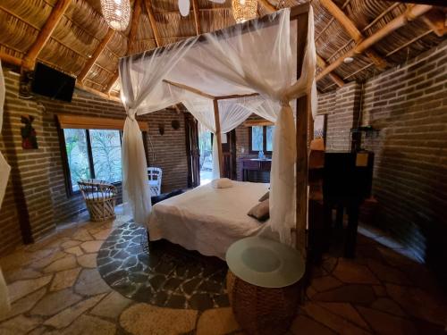 una camera con letto a baldacchino di Eco Hotel Tahawi a Ajijic