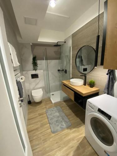 a bathroom with a shower and a washing machine at Z8 Prémium Apartman in Kaposvár