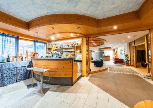 una cucina con bar in una stanza con pareti in legno di Alpine Mugon Hotel a Vason