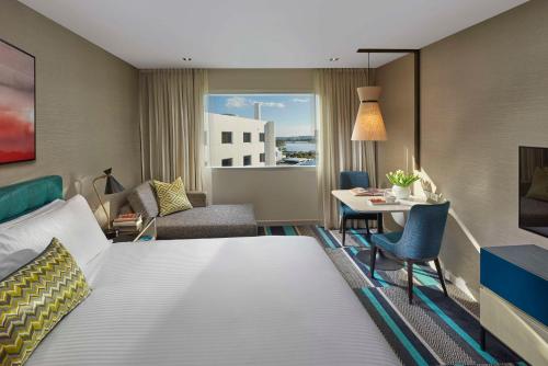 Crown Promenade Perth في بيرث: غرفة فندقية بسرير كبير وطاولة