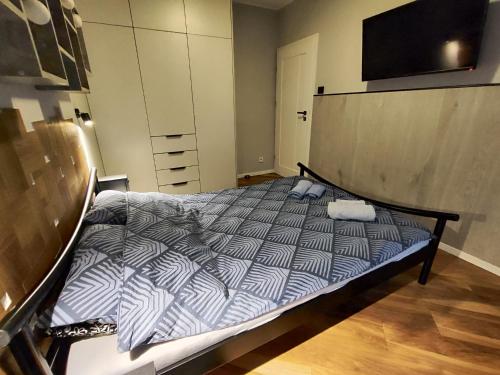 een slaapkamer met een bed en een tv aan de muur bij JR Smolna in Poznań