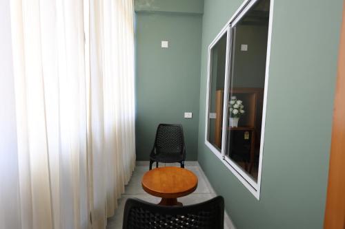 a room with a table and a chair and a mirror at Riders Den in Mananthavady