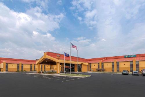 ein großes Gebäude mit amerikanischer Flagge auf einem Parkplatz in der Unterkunft Quality Inn Fort Wayne in Fort Wayne