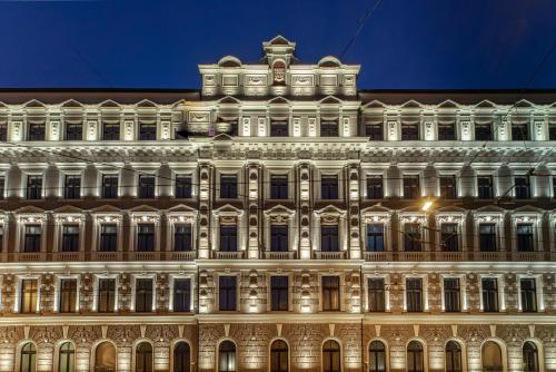 un edificio iluminado por la noche en Aparthotel Amella, en Riga