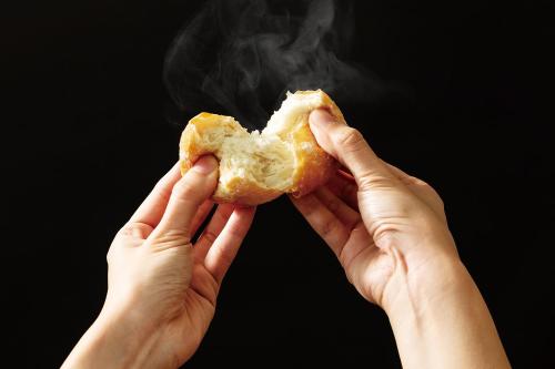 eine Person, die einen Donut in den Händen hält in der Unterkunft Smile Hotel Nara in Nara