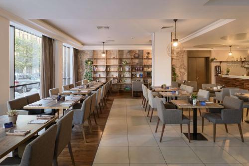 a dining room with long tables and chairs at Radisson Blu Hotel, Kyiv Podil City Centre in Kyiv