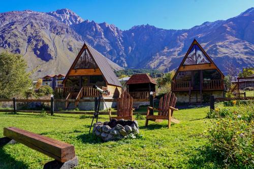 ein Resort mit einer Feuerstelle, Stühlen und Bergen in der Unterkunft Hillside Kazbegi in Kazbegi