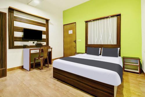 Dormitorio con cama, escritorio y TV en Super Hotel O Porvorim Near Mall De Goa, en Panaji