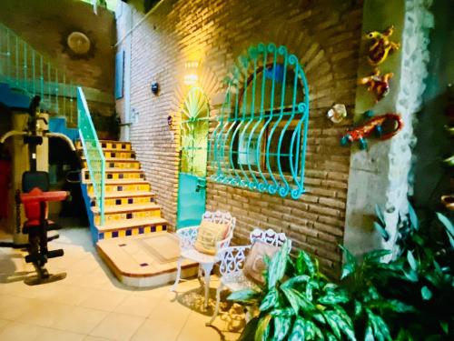 a room with chairs and a wall with a mural at Casa Cereza Apartments in Puerto Vallarta