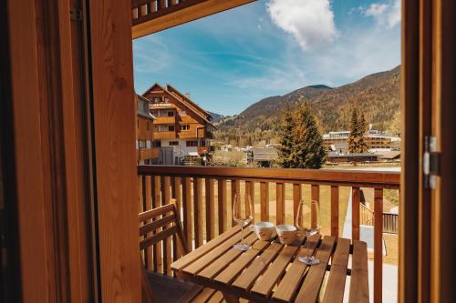 - un balcon en bois avec une table et des verres à vin dans l'établissement Goldhorn Chalet, à Kranjska Gora