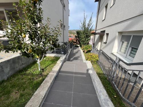 a sidewalk next to a building with a tree at Apartment Mejdan in Tuzla