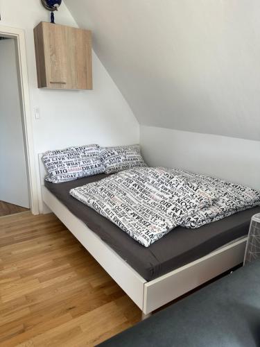 uma cama num quarto com uma parede branca em PL Home em Kehl am Rhein