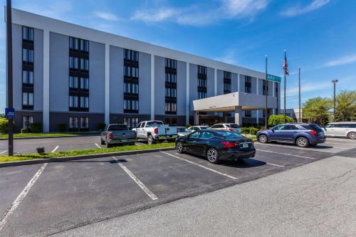 un gran edificio con coches estacionados en un estacionamiento en Allentown Park Hotel, Ascend Hotel Collection, en Allentown