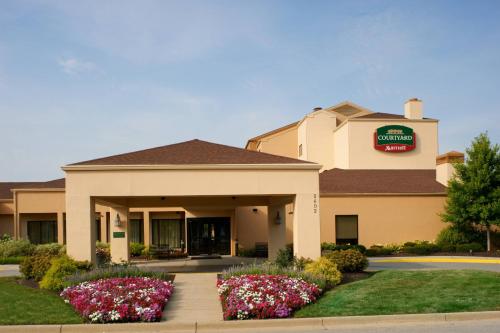 um hotel com flores em frente a um edifício em Courtyard by Marriott Indianapolis Airport em Indianápolis