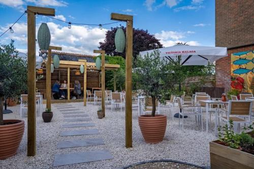 a patio with tables and chairs and an umbrella at Lento Apartment in Winchester