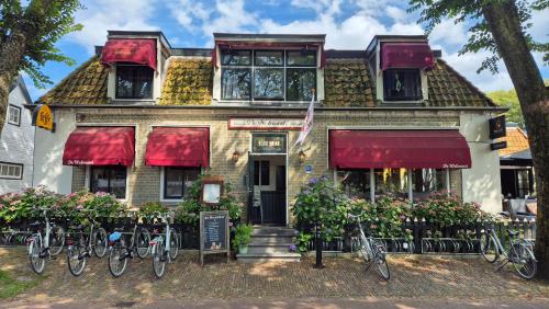 ein Haus mit Fahrrädern, die davor geparkt sind in der Unterkunft De Welvaart - Logement in Hollum