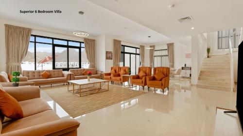 a living room with couches and chairs and a table at Al Dana Paradise Luxury Villas Palm Fujairah Sea View in Fujairah