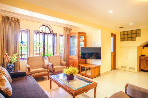 un soggiorno con divano e TV di 'Golden Oceans' 3 bhk beach view villa a Benaulim