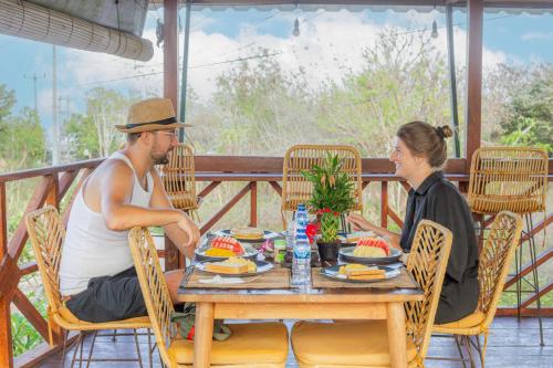 un hombre y una mujer sentados en una mesa en Blue Lagoon Secret Villas, en Nusa Lembongan