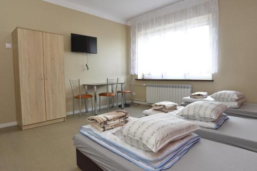 een kamer met drie bedden en een tafel met stoelen bij Kamienica - mieszkanie dwupokojowe in Skarżysko-Kamienna