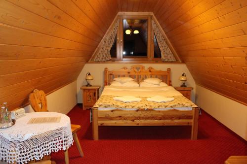 um quarto com uma cama grande num sótão em Zakopiański Dwór em Zakopane