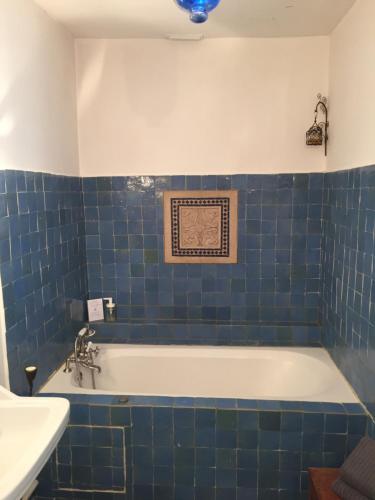 ein blau gefliestes Bad mit einer Badewanne und einem Waschbecken in der Unterkunft L'académie de Clémence, Guest House Paris-Roland-Garros in Boulogne-Billancourt