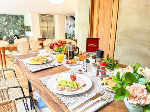 una mesa de madera con platos de comida. en Lucitania Hotel Boutique, en Bogotá