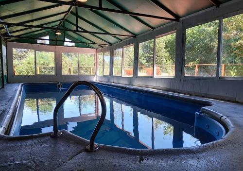 an empty swimming pool in a building with windows at Ruma Andina by DOT Cabana in Villa La Angostura